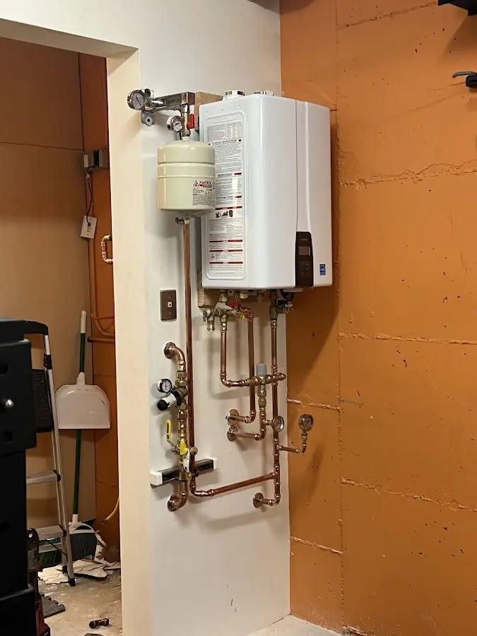 Plumbing technician inspecting water heater connections in Springhill